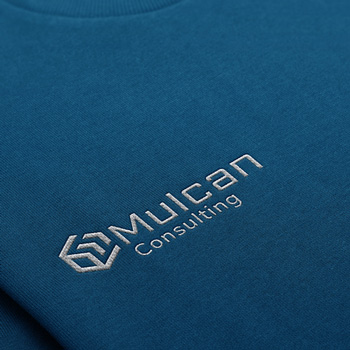 Mulcan Consulting Logo haftowane srebrną nicią na swetrze